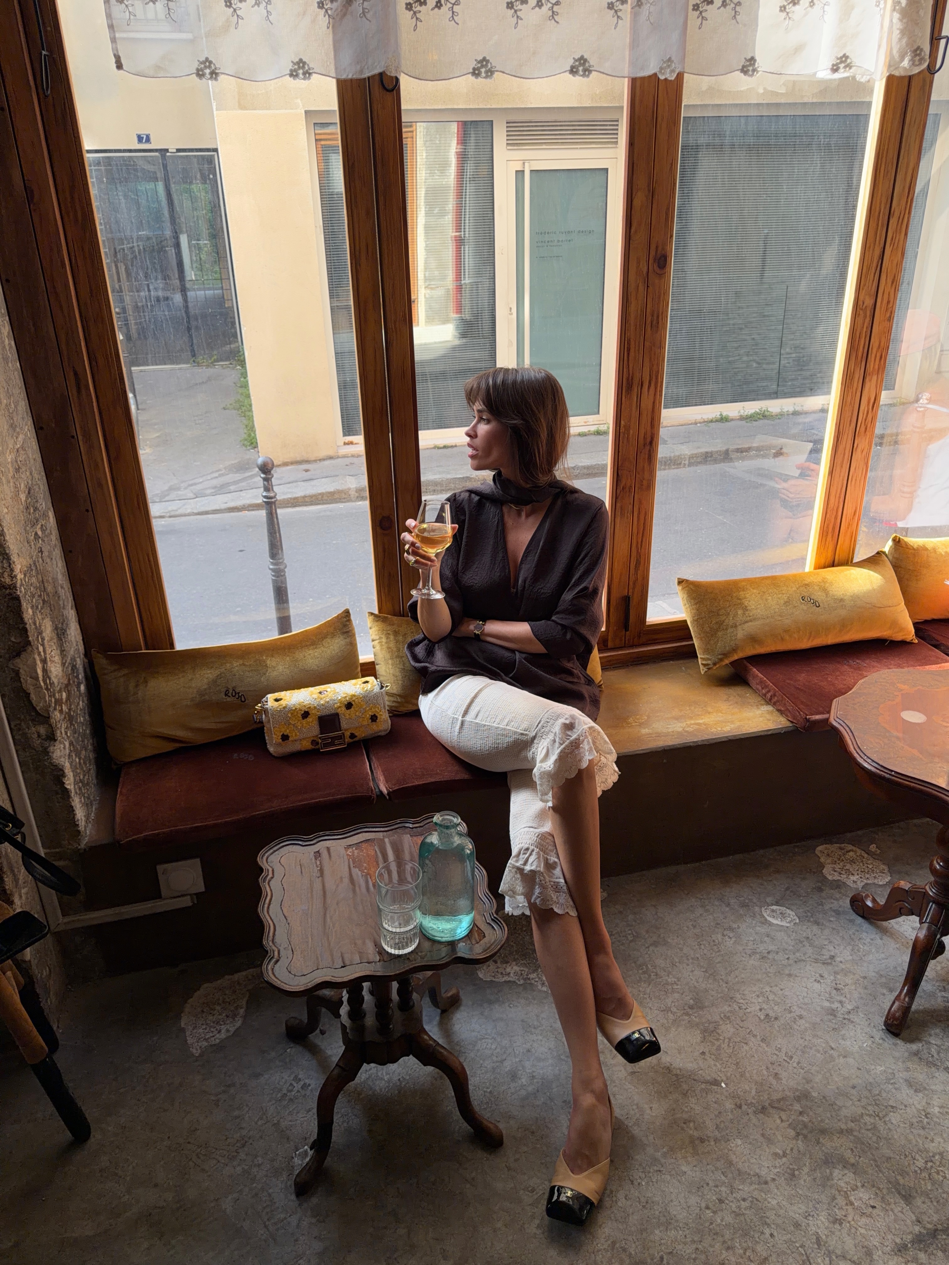 @alisontoby 穿著荷葉邊長短褲、黑色襯衫和香奈兒雙色高跟鞋的照片。
