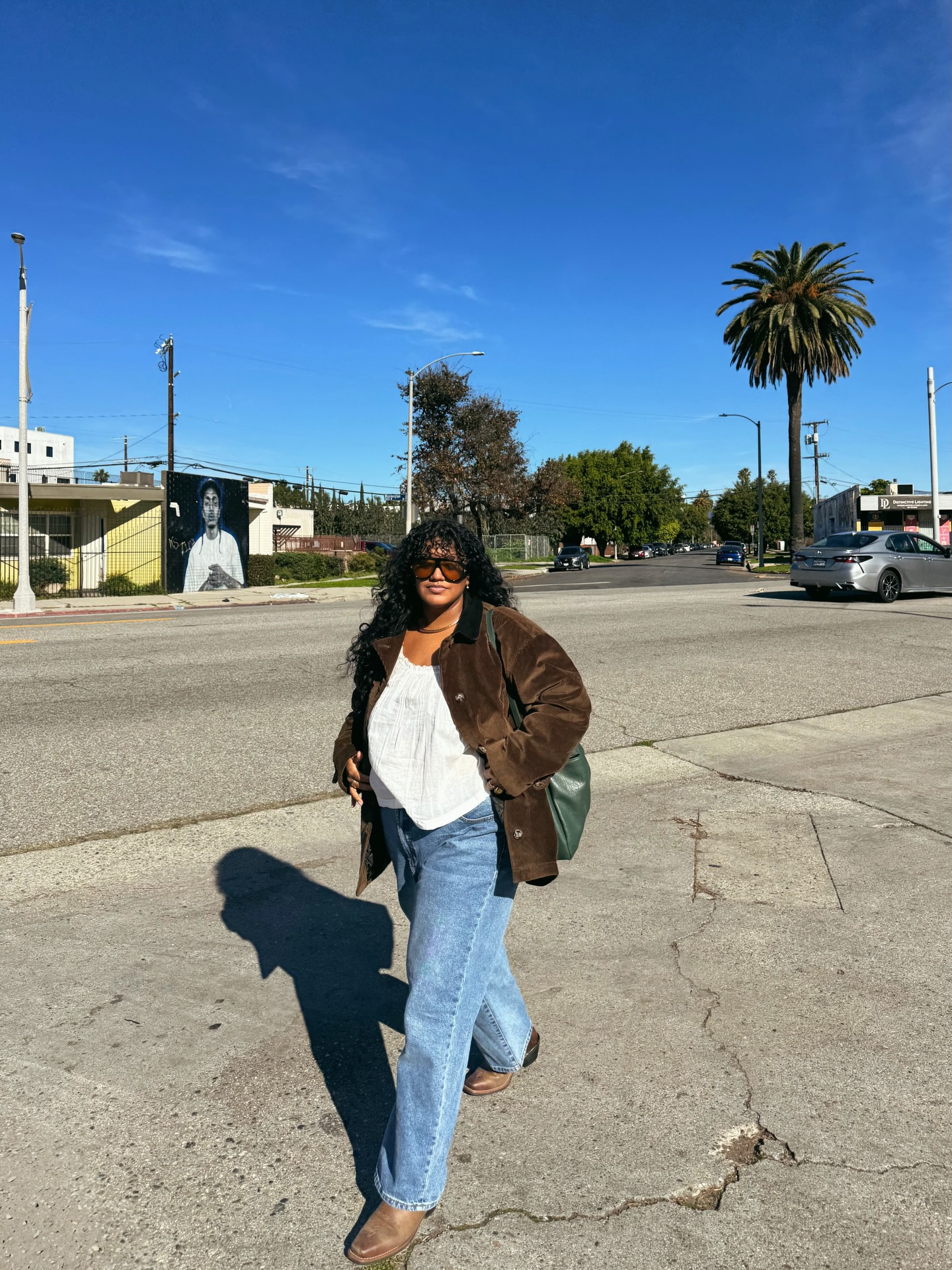 影響者 Veronica Campos 穿著波西米亞風上衣、絨面革夾克、直筒牛仔褲和靴子。