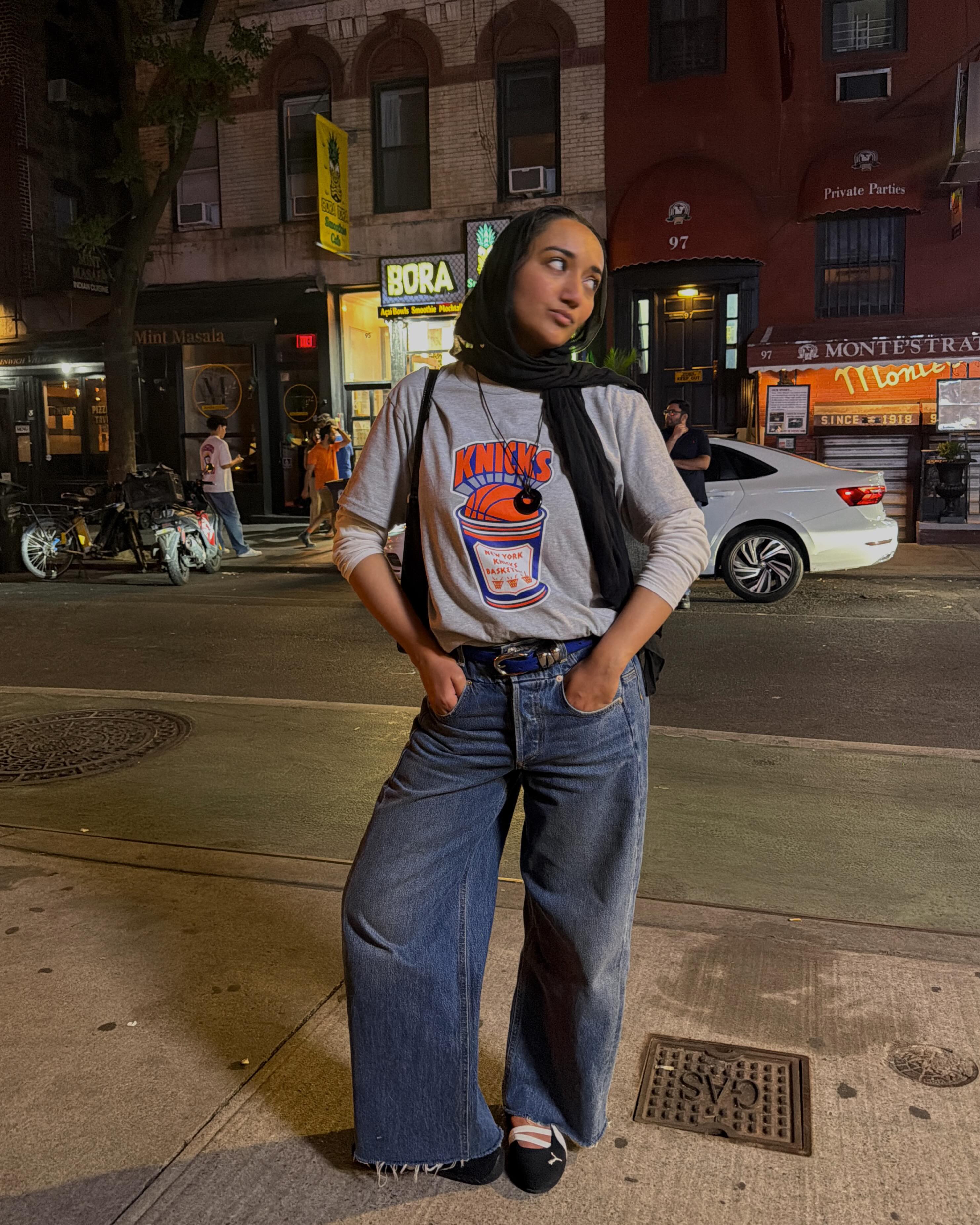 網紅尤斯拉·西迪基 (Yusra Siddiqui) 穿著短袖 T 卹搭配長袖 T 卹，搭配寬腿牛仔褲和芭蕾舞鞋。