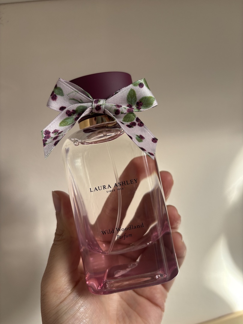 Mica Ricketts 拿著 Laura Ashley Wild Woodland 的瓶子