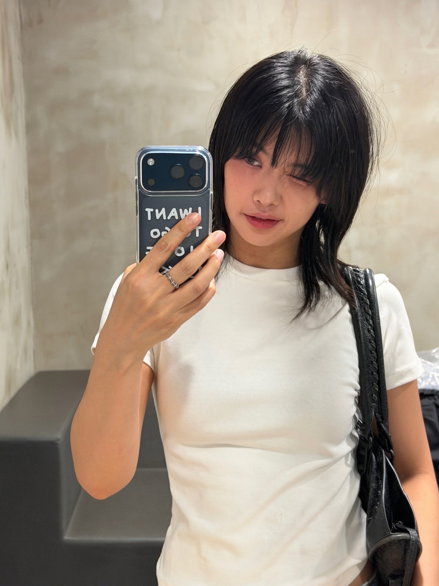 一位留著蓬亂髮型的女士對著鏡子自拍。