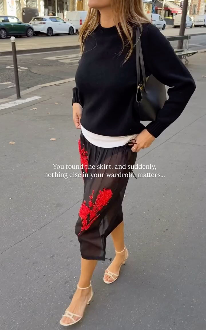 女人穿著透明的紅色繡花裙子和毛衣。