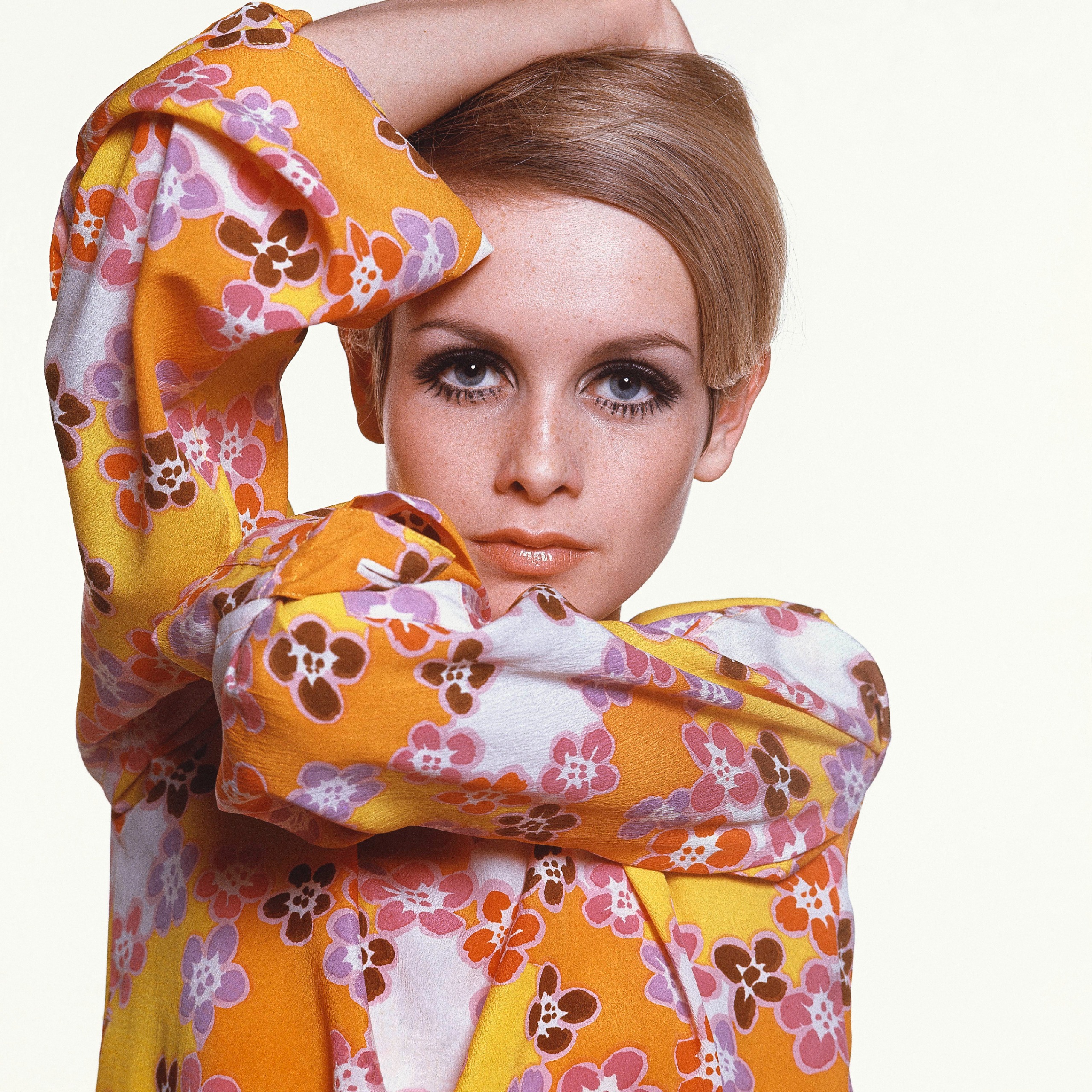 Twiggy 化著蜜絲佛陀 (Max Factor) 妝容，身穿 Michele Rosier 設計的花卉縐紗連身裙。