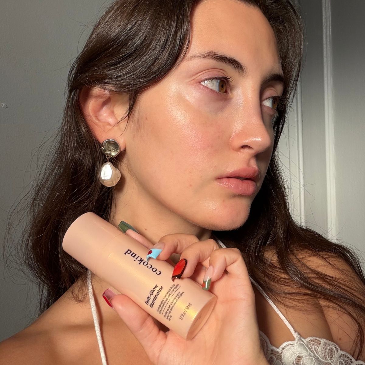 WWW 美容副編輯 Alyssa Brascia 手持新款 Cocokind Soft-Glow Illuminator 的圖片。